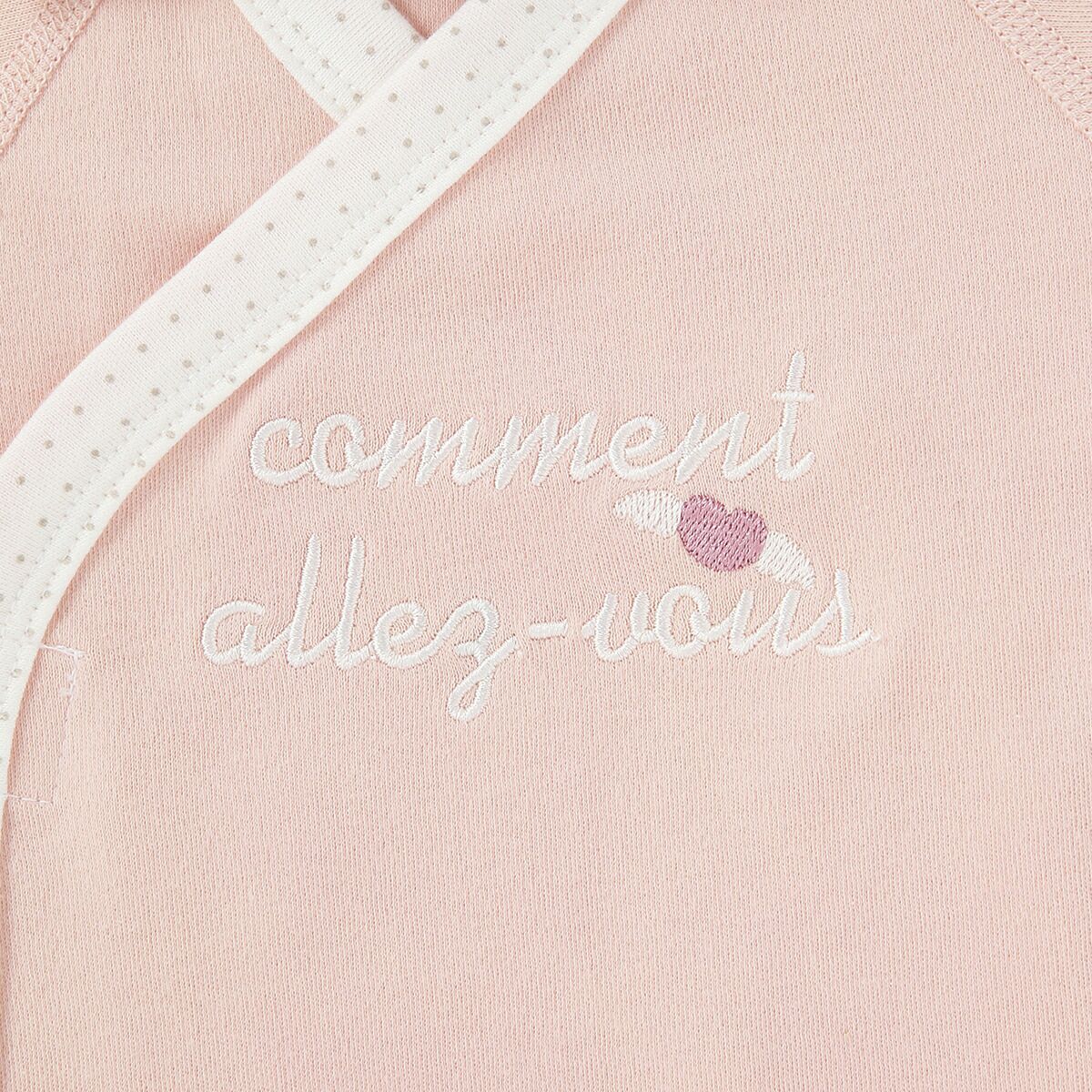 胸元にあしらった刺しゅうはフランス語でごきげんようという意味の言葉。赤ちゃんの健やかな毎日を願うママの思いが込められています。